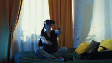 Günlük giysiler içinde beyaz bir kız sanal dünyada yenilikçi teknoloji ve dijital konsepti temsil eden VR kulaklık takıp öğreniyor. Geniş açı.