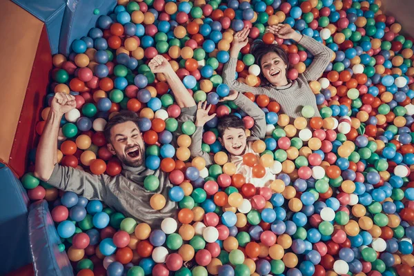 Top shot de una familia acostada en una piscina con bolas. —  Fotos de Stock