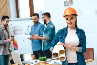 Kız elinde kağıtlarla ayakta duruyor..