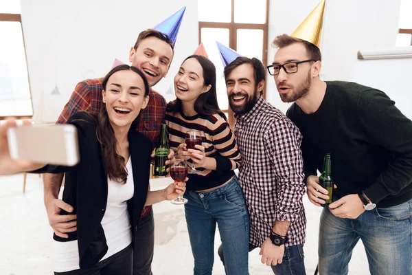 Los jóvenes con gorras de vacaciones hacen selfie. —  Fotos de Stock