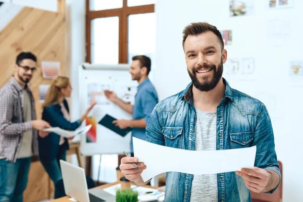 Ein Mann in Jeans blickt in die Kamera und lächelt. — Stockfoto