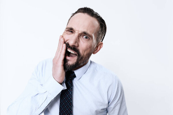 A man with severe pain in his teeth clings to him.