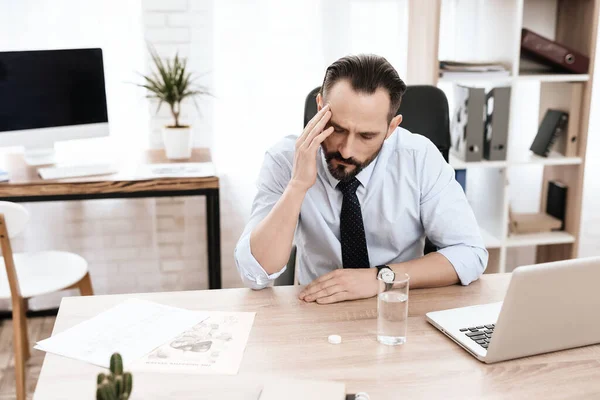 Un hombre se sienta en la mesa de madera y trabaja en la computadora. — Foto de Stock