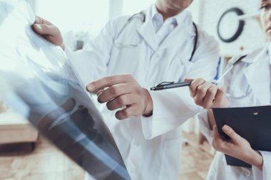 Kadın röntgende kalemle bir şey gösteriyor.. 