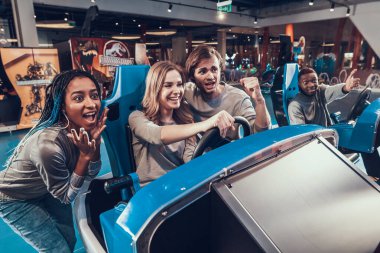 Sarışın, oyuncak bir arabanın direksiyonunda oturuyor..