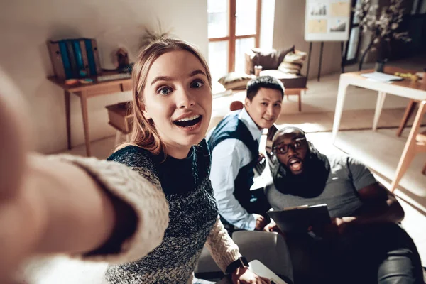 Mujer tomando selfie con colegas en la oficina. — Foto de Stock