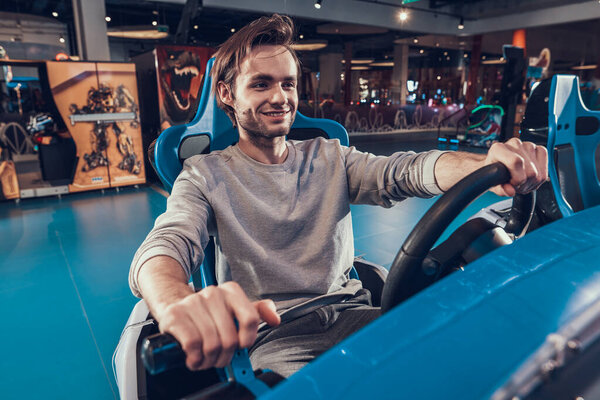 Man sits behind toy car in an entertainment center