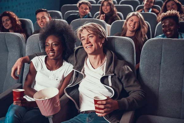 Young man with African American woman at cinema.