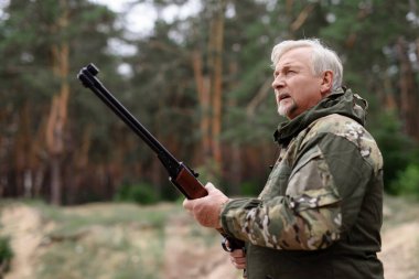 Av tüfekli dikkatli avcı yukarı bakıyor..