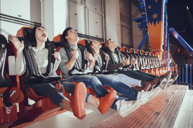 Arkadaşlar atlıkarıncada otururken yukarı bakıyor.. 