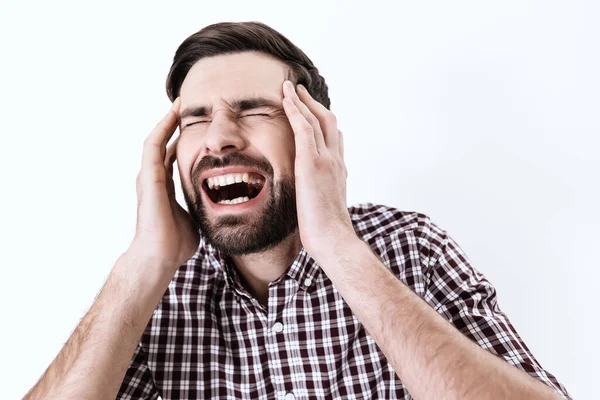 Un uomo urla mentre mette le mani sulla testa dolorante. — Foto Stock