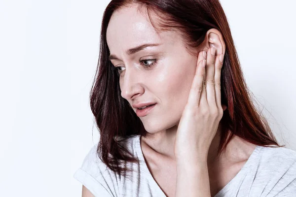 Mujer sobre fondo blanco con dolor de oído agudo. — Foto de Stock