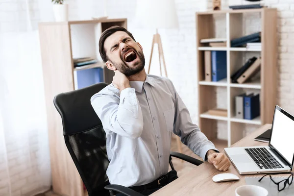 Um homem senta-se à mesa e sente dor intensa. — Fotografia de Stock