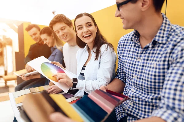 Chica muestra colores a sus colegas y sonrisas. — Foto de Stock