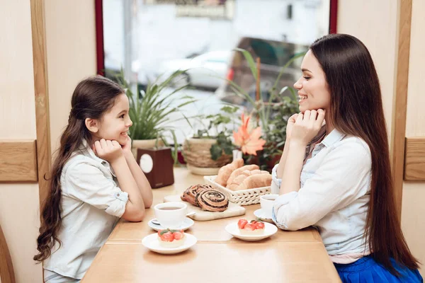 Mère avec fille manger des gâteaux à la cafétéria. — Photo