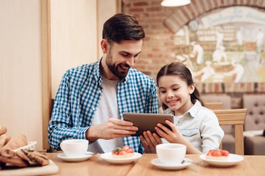 Baba ve kızı kafeteryada kek yiyorlar..