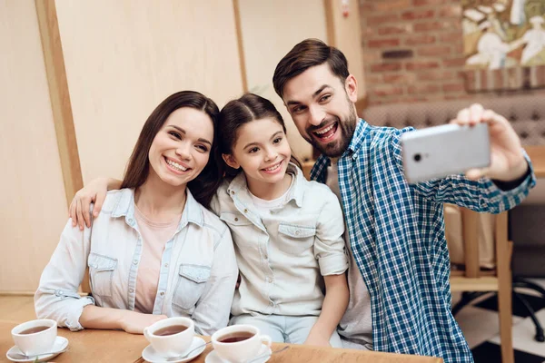 Junge glückliche Familie macht Selfie in Cafeteria. — Stockfoto
