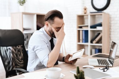 Gömlekli bir adam başını tutar ve acı hisseder.. 