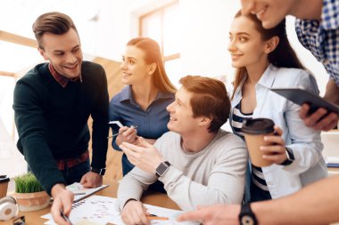 Bir adam meslektaşına bakar ve onunla konuşur..