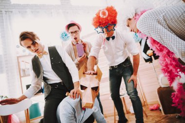 Arkadaşlar etraftayken gay adam dört ayak üstünde oturur.