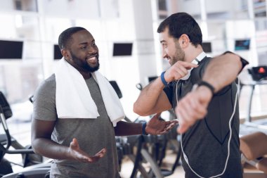 Modern spor salonundaki hipodromlarda iki adam iletişim kuruyor..