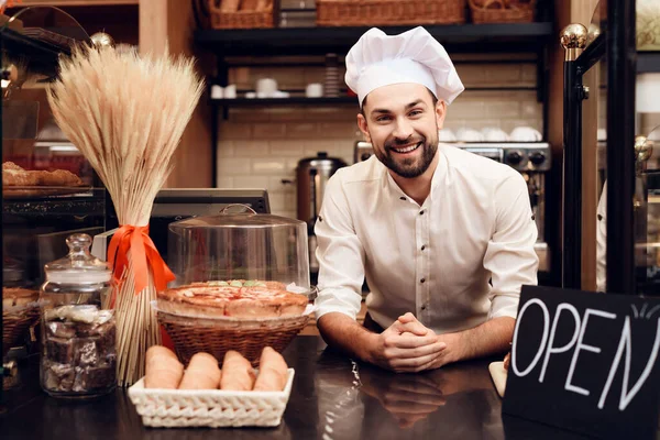 Jonge man met baard in schort staand in de bakkerij. — Stockfoto