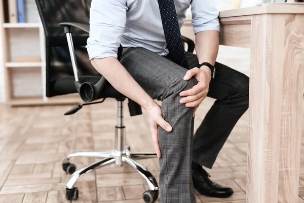 Un joven tiene un dolor en la pierna.. — Foto de Stock