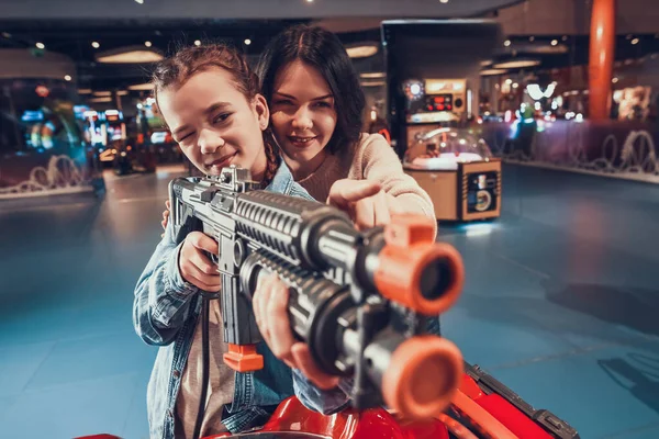 Mom shows her son how to aim from a slot machine.