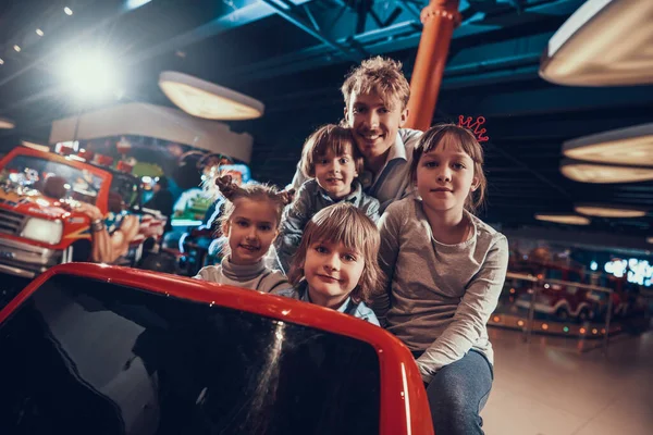 Niños alegres con papá en el centro de entretenimiento —  Fotos de Stock