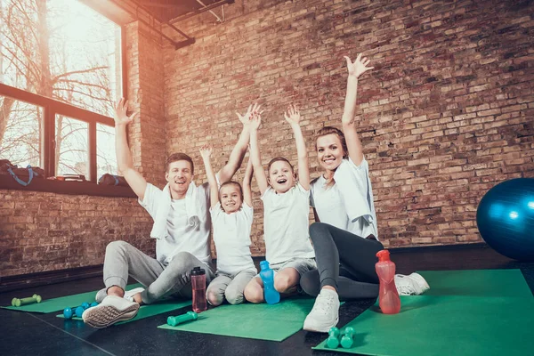 Sport Rodzina usiąść na dywanie siłowni podczas przerwy. — Zdjęcie stockowe