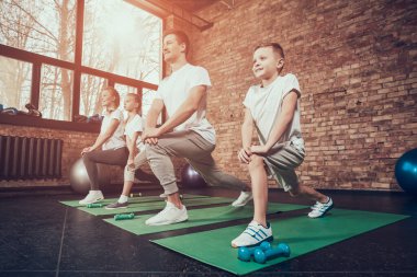 Spor salonundaki genç aile egzersiz yapıyor ve gülümsüyor.. 