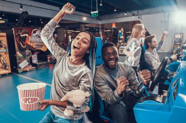 Alışveriş merkezindeki insanlar kumar makineleriyle kendilerini eğlendiriyorlar.