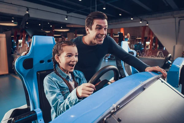 Babası küçük kızına oyunlarda araba kullanmasında yardım ediyor.. — Stok fotoğraf