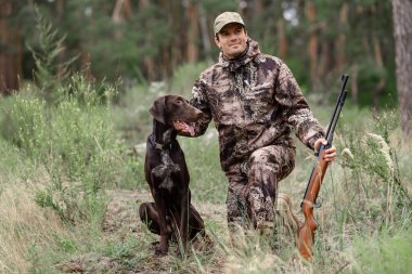 Tüfekli adam yaz doğasında avlanırken eğleniyor..