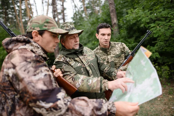 Hunters Watching Map Route Planning in Forest.