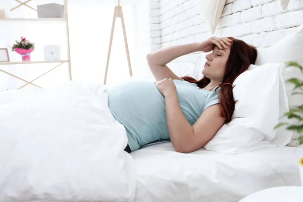 A woman lies in bed and feels that her head hurts. — Stock Image A woman lies in bed and feels that her head hurts. Stock Photo