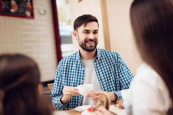 Junge glückliche Familie isst Kuchen in Cafeteria. — Stockfoto