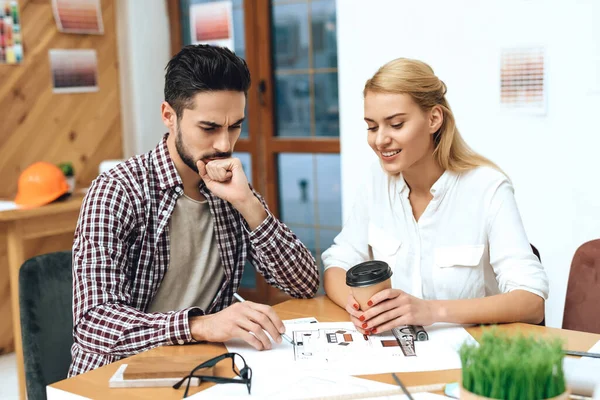 Ein Mann sitzt mit einem Mädchen an einem Tisch und bespricht die Arbeit — Stockfoto