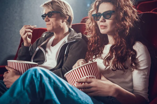 一个漂亮的女人和一个男人坐在电影院里. — 图库照片