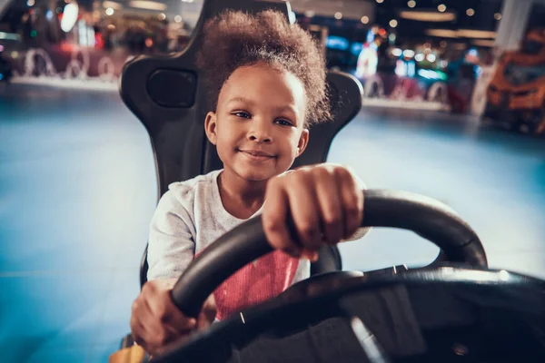 Menina segurando roda enquanto joga corrida virtual. — Fotografia de Stock