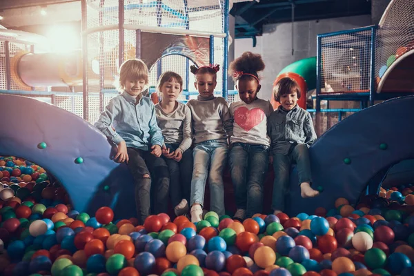 遊園地で一緒に座っている子供たち. — ストック写真