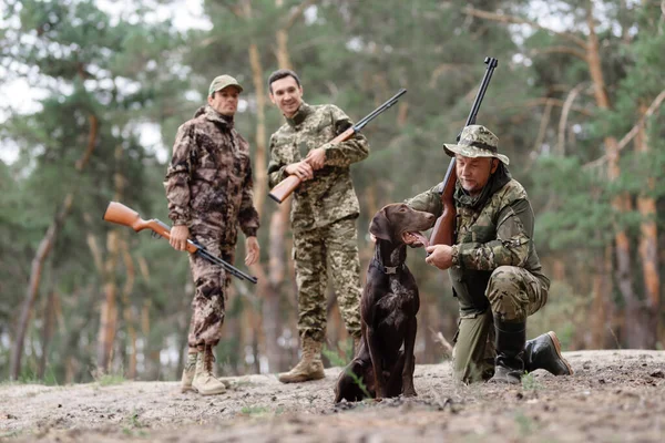 Amigos o familiares con pistola de caza de perros en el bosque. — Foto de Stock