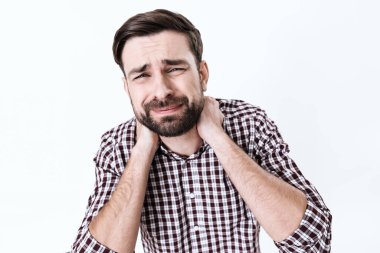 Gömlekli bir adam büyük bir acıyla ayakta duruyor..