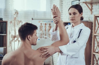 Doktor atlet ellerinin motor becerilerini kontrol eder..