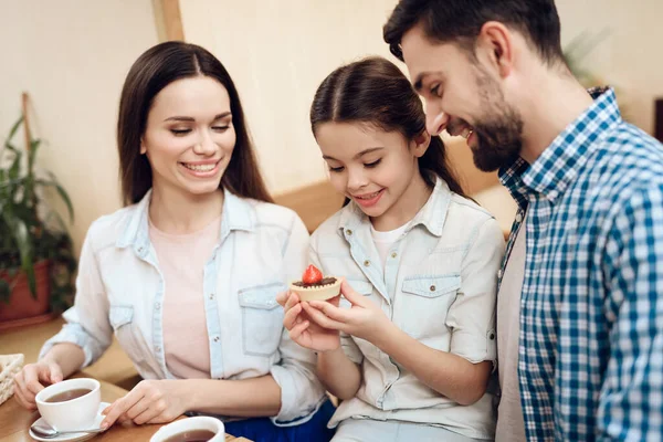 Jeune famille heureuse manger des gâteaux à la cafétéria. — Photo