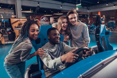 Siyah adam gülümsüyor ve oyun odasında araba sürüyor.. 