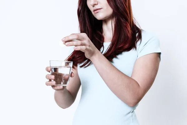 Mujer vierte medicina en un vaso de agua. — Foto de Stock