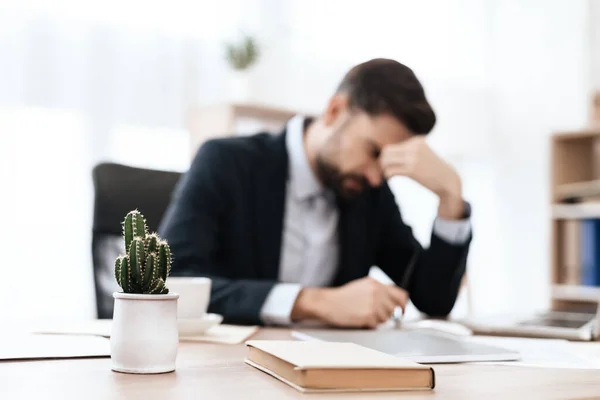 A man sits in a suit and suffers from headaches. — Stock Photo, Image