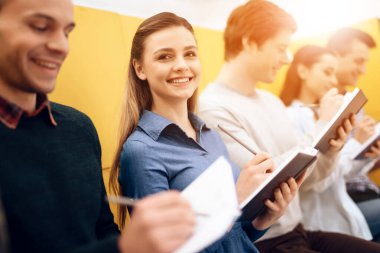 Güzel kız deftere yazarken gülümsüyor..