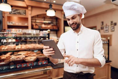 Beyaz Başlıklı Sakallı Adam Fırında Tablet Kullanıyor.